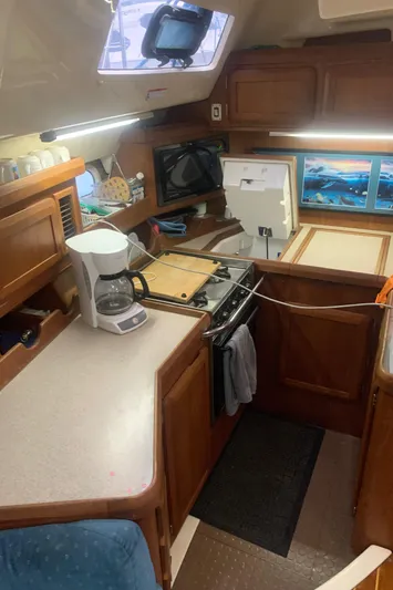  Yacht Photos Pics 1998 Hunter Passage 42 yacht kitchen with stove, coffee maker, and wooden cabinetry.