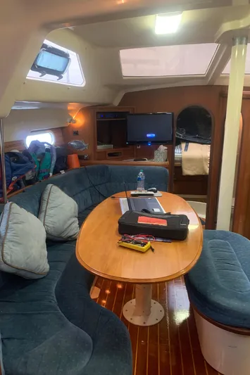  Yacht Photos Pics Interior of 1998 Hunter Passage 42 sailboat with cozy seating and wooden table.