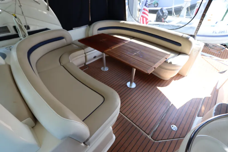  Yacht Photos Pics 2004 Sea Ray 420 Sundancer interior with curved seating and wooden table.