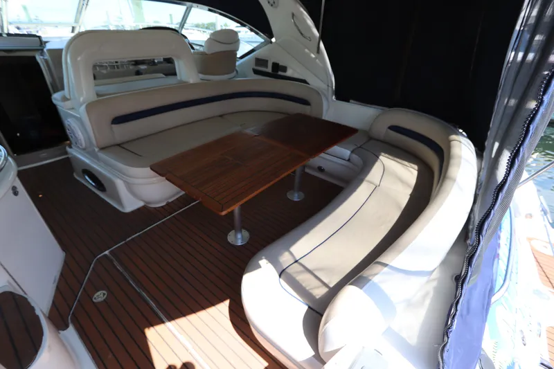 Yacht Photos Pics 2004 Sea Ray 420 Sundancer interior with curved seating and wooden table.