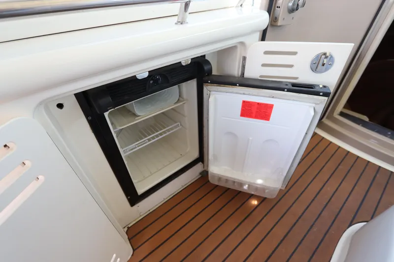  Yacht Photos Pics Open mini fridge on 2004 Sea Ray 420 Sundancer boat with wood-style flooring.
