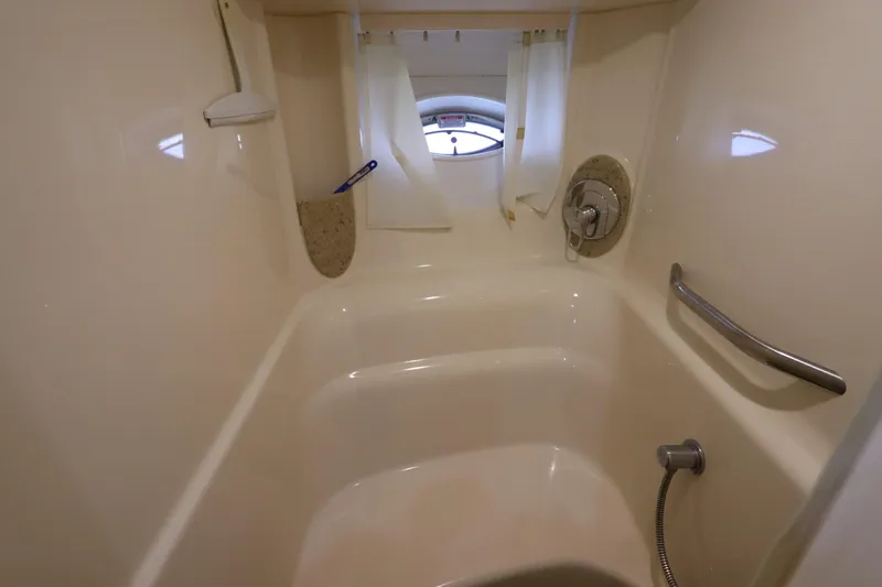  Yacht Photos Pics Bathroom interior of 2004 Sea Ray 420 Sundancer yacht, featuring shower and porthole window.