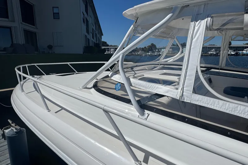  Yacht Photos Pics 2012 Intrepid 390 Sport Yacht with white canopy and railing, docked near waterfront buildings.