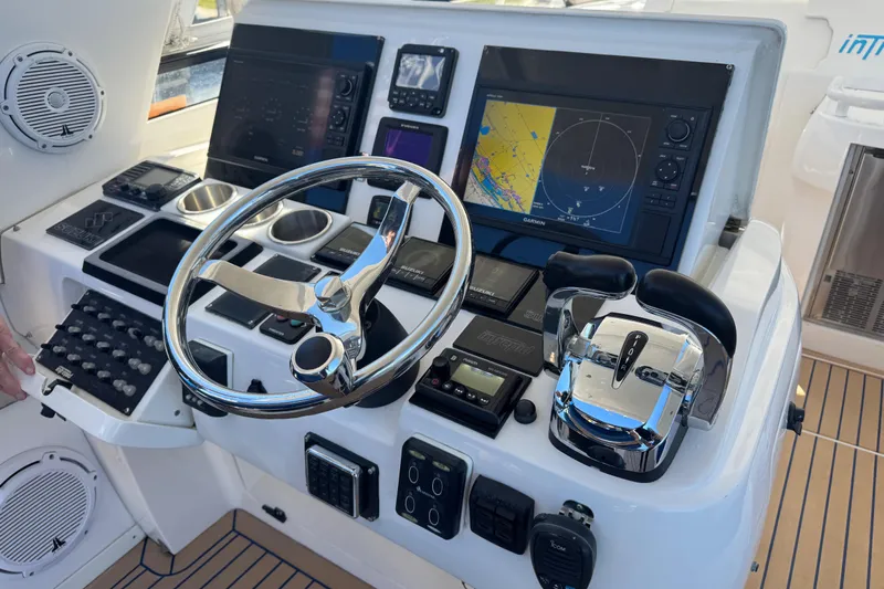  Yacht Photos Pics Control panel of a 2012 Intrepid 390 Sport Yacht with navigation screens and steering wheel.