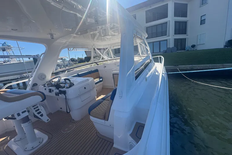  Yacht Photos Pics 2012 Intrepid 390 Sport Yacht docked, showcasing sleek interior and helm under bright sunlight.