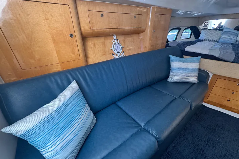  Yacht Photos Pics Luxurious interior of 2012 Intrepid 390 Sport Yacht with blue sofa and wooden cabinetry.