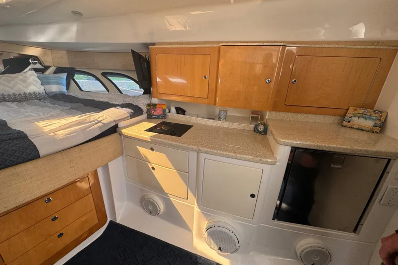  Yacht Photos Pics Interior of 2012 Intrepid 390 Sport Yacht with bed, cabinets, and kitchenette.