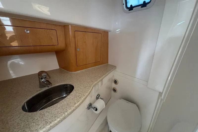  Yacht Photos Pics 2012 Intrepid 390 Sport Yacht bathroom with sink, toilet, and wooden cabinets.