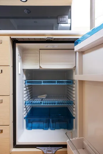 V40188 Yacht Photos Pics Compact refrigerator inside 2024 Princess V40 yacht, featuring blue shelves and modern design.