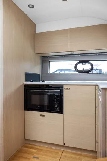 V40188 Yacht Photos Pics Modern kitchen interior of 2024 Princess V40 yacht with microwave and sleek cabinetry.