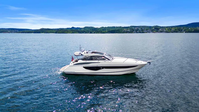 V40188 Yacht Photos Pics 2024 Princess V40 yacht cruising on a serene lake under a clear blue sky.