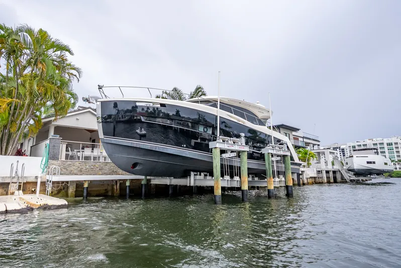 Pier Pressure Yacht Photos Pics Carver C52 Coupe 2017 on a boat lift by the water.