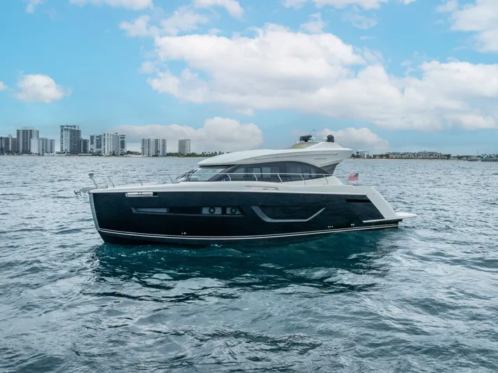 Pier Pressure Yacht Photos Pics 2017 Carver C52 Coupe yacht on the sea with city skyline.