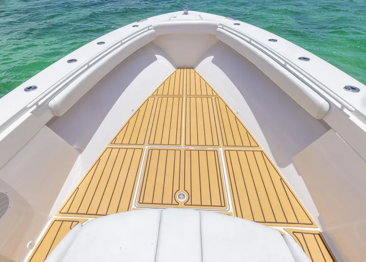  Yacht Photos Pics Bow view of 2021 HCB 53 Sueños boat with teak deck and ocean backdrop.