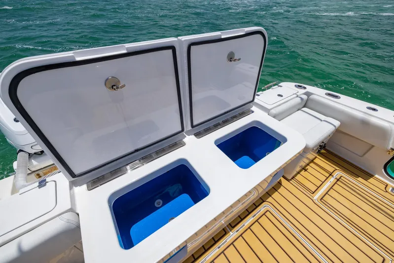  Yacht Photos Pics HCB 53 Sueños 2021 boat with open storage compartments on deck, near ocean.