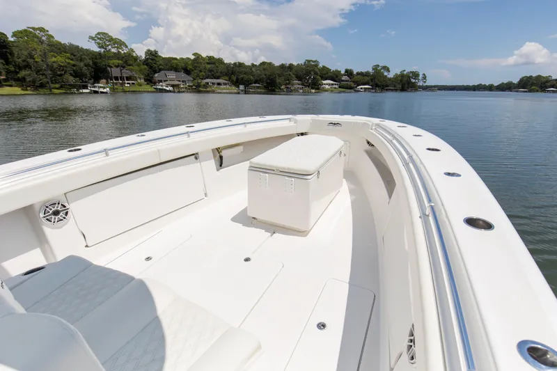  Yacht Photos Pics 2020 Invincible 39 Open Fisherman boat on calm lake with scenic shoreline.