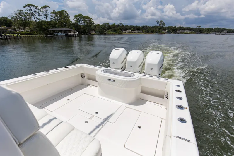  Yacht Photos Pics 2020 Invincible 39 Open Fisherman boat with triple engines cruising on a calm lake.