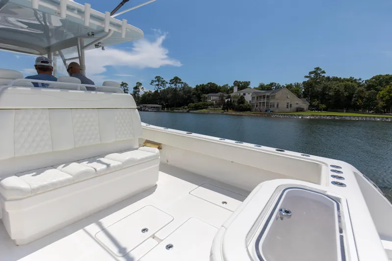  Yacht Photos Pics 2020 Invincible 39 Open Fisherman boat interior with white seating, cruising on a scenic waterway.