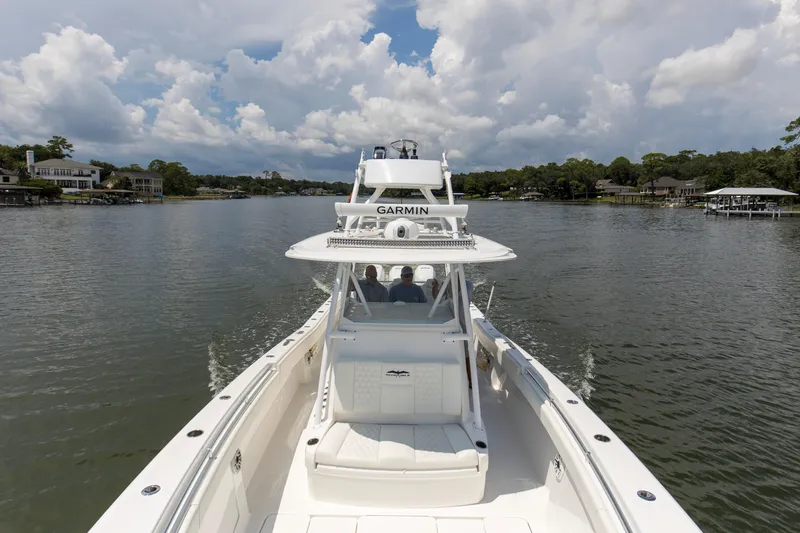  Yacht Photos Pics 2020 Invincible 39 Open Fisherman cruising on a scenic waterway under cloudy skies.