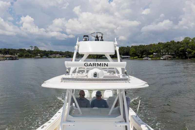  Yacht Photos Pics 2020 Invincible 39 Open Fisherman boat on a calm lake under cloudy skies.