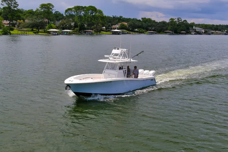  Yacht Photos Pics 2020 Invincible 39 Open Fisherman boat cruising on a scenic lake.