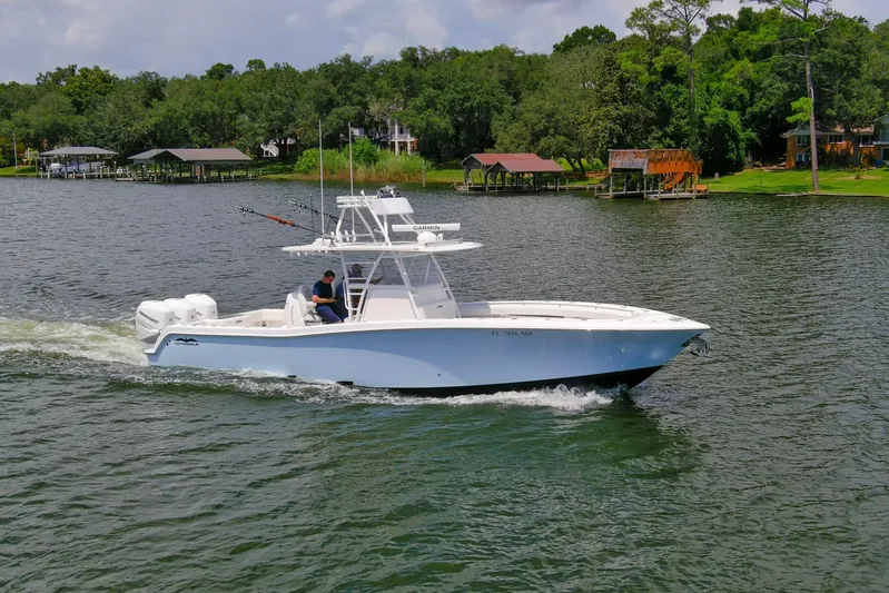  Yacht Photos Pics 2020 Invincible 39 Open Fisherman boat cruising on a scenic lake.