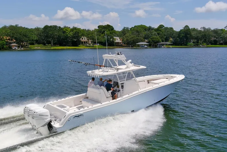  Yacht Photos Pics 2020 Invincible 39 Open Fisherman boat cruising on a scenic lake.