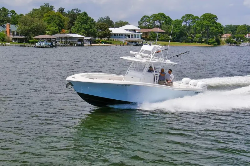  Yacht Photos Pics 2020 Invincible 39 Open Fisherman boat cruising on a scenic lake.