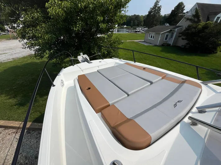  Yacht Photos Pics 2023 Beneteau Flyer 9 SUNdeck with cushioned sunbathing area, docked near a house.