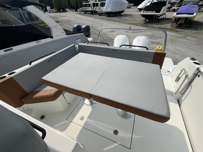  Yacht Photos Pics 2023 Beneteau Flyer 9 SUNdeck boat interior with seating and table, docked outdoors.