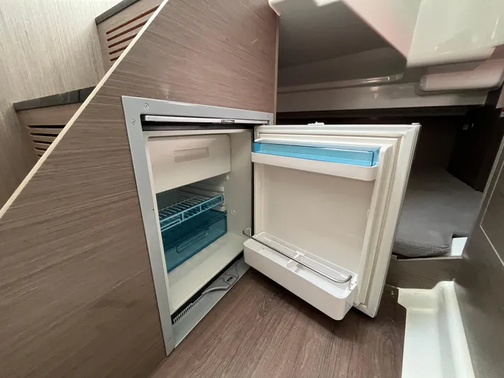  Yacht Photos Pics 2023 Beneteau Flyer 9 SUNdeck interior with open mini fridge under stairs.