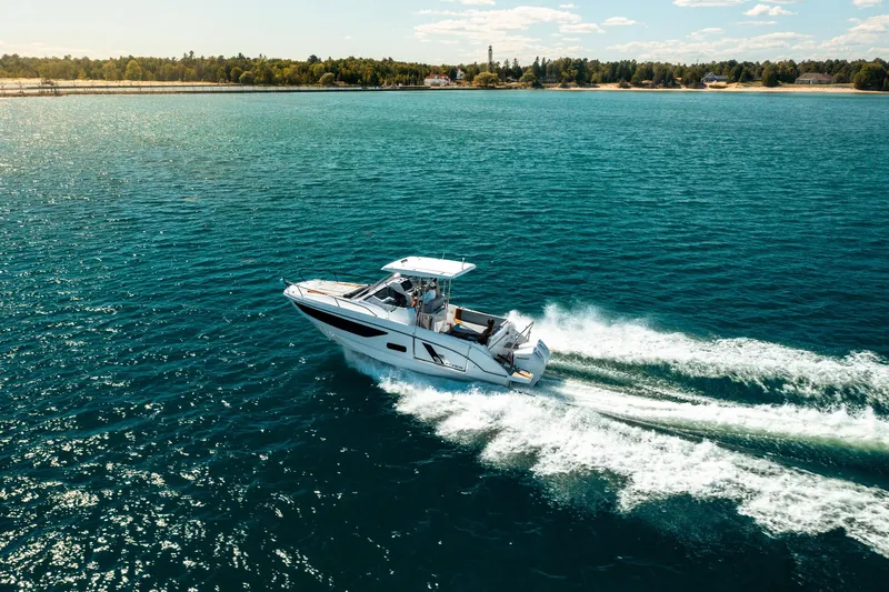  Yacht Photos Pics 2023 Beneteau Flyer 9 SUNdeck cruising on open water, with scenic coastline in the background.