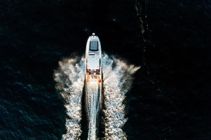  Yacht Photos Pics Aerial view of 2023 Beneteau Flyer 9 SUNdeck speeding on dark water.