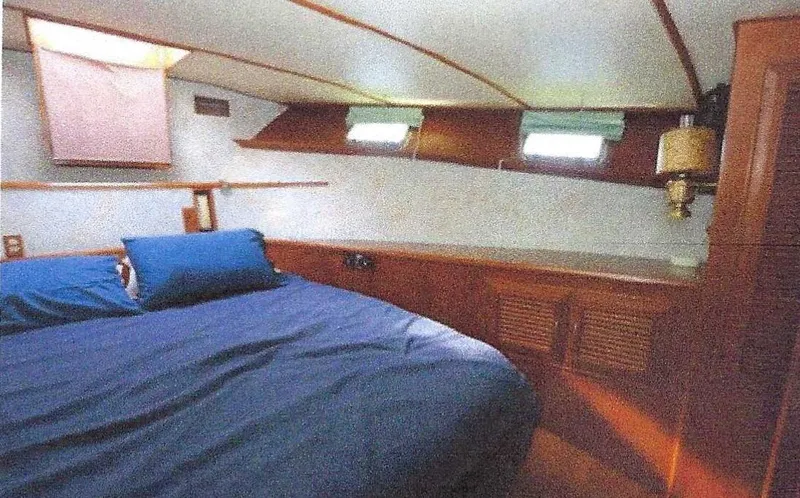 Wendy Lynn Yacht Photos Pics 1984 Ocean Alexander Flying Bridge Motor Yacht cabin with bed, wooden cabinetry, and small windows.