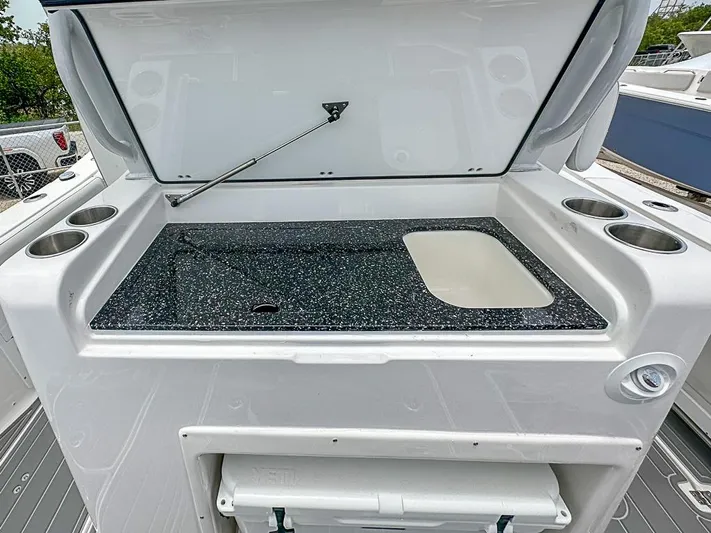  Yacht Photos Pics 2024 Sea Fox 328 Commander boat with open storage compartment and cup holders.