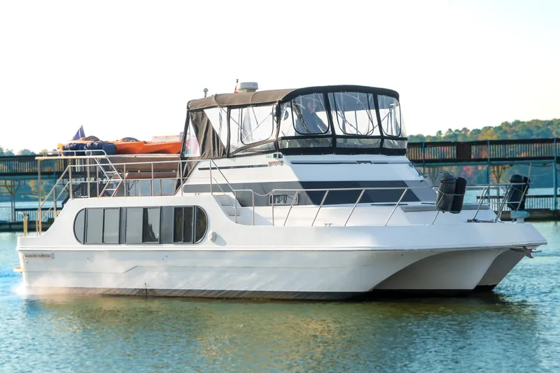 Jolly Roger II Yacht Photos Pics 1997 Harbor Master Stolkraft boat docked on calm water, featuring a sleek design.