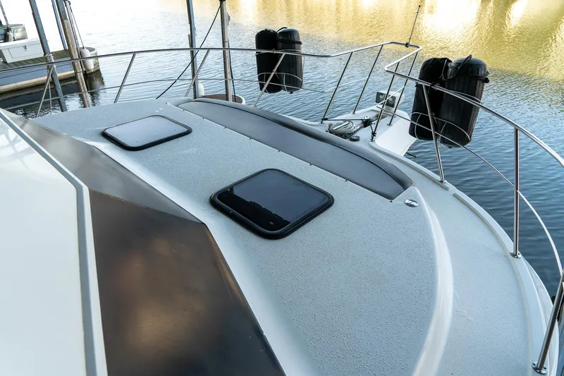 Jolly Roger II Yacht Photos Pics 1997 Harbor Master Stolkraft boat deck with hatches, docked on calm water.