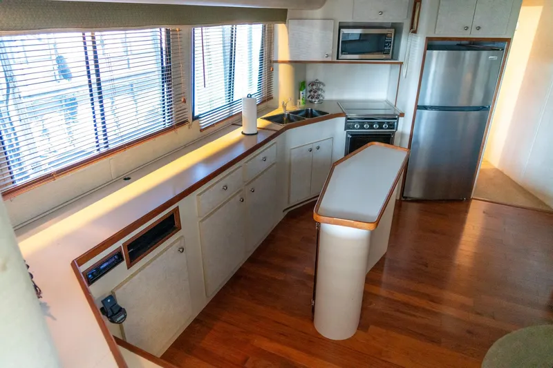 Jolly Roger II Yacht Photos Pics Modern kitchen interior of 1997 Harbor Master Stolkraft boat with wooden flooring.