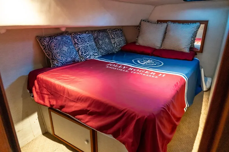 Jolly Roger II Yacht Photos Pics Cozy cabin bedroom in 1997 Harbor Master Stolkraft with decorative pillows and nautical bedding.