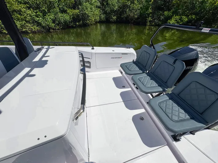  Yacht Photos Pics 2024 Axopar 37 Sun Top boat interior with seating, on a calm waterway.