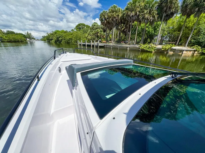  Yacht Photos Pics 2024 Axopar 37 Sun Top cruising on a scenic river with lush greenery.