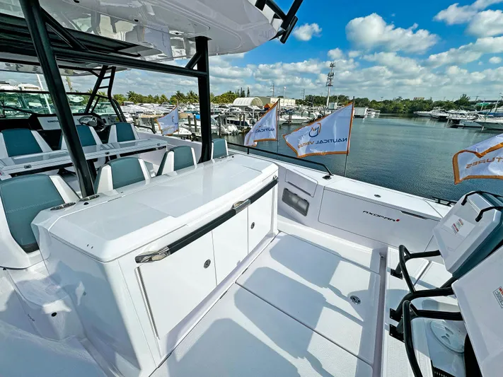  Yacht Photos Pics 2024 Axopar 37 Sun Top boat interior with seating and storage, docked by a marina.