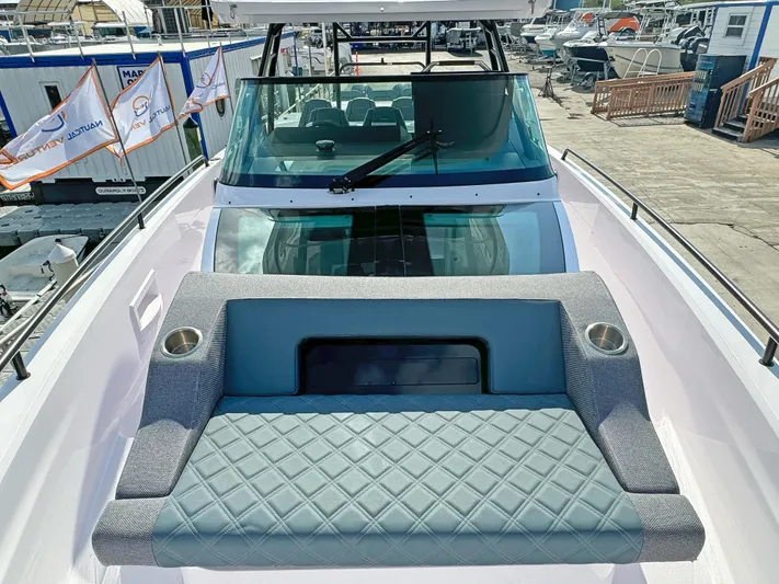  Yacht Photos Pics 2024 Axopar 37 Sun Top boat with cushioned seating and sleek windshield design.