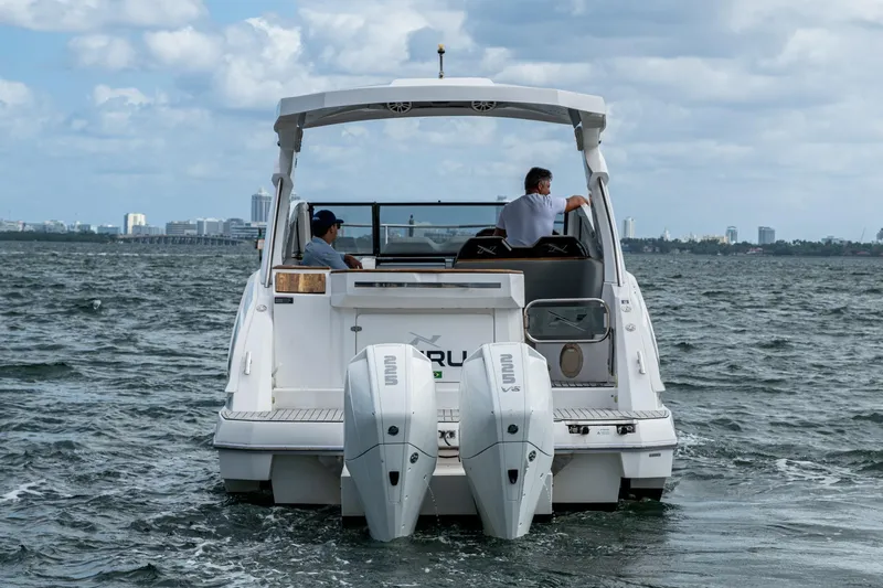 Xuru Yacht Photos Pics 2023 NX 340 boat cruising on open water with city skyline in background.
