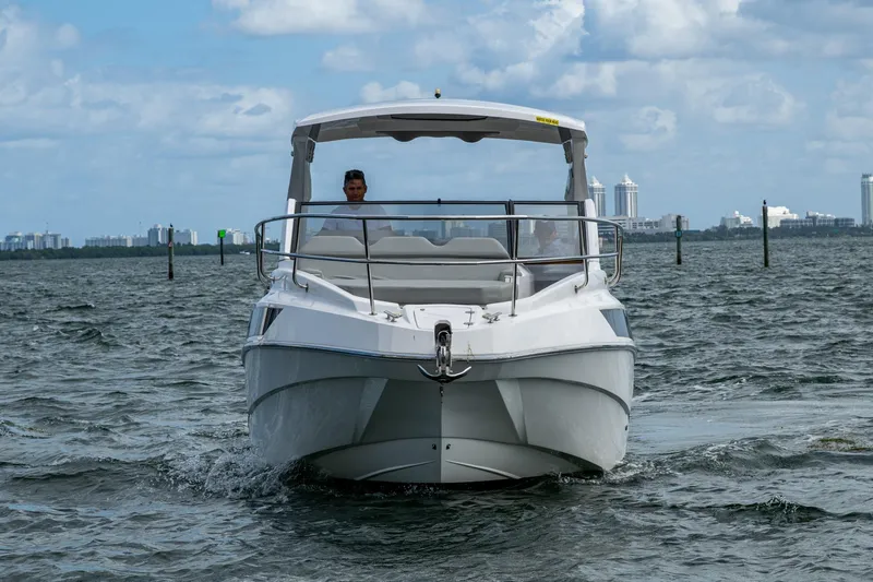 Xuru Yacht Photos Pics 2023 NX 340 boat cruising on open water with city skyline in background.