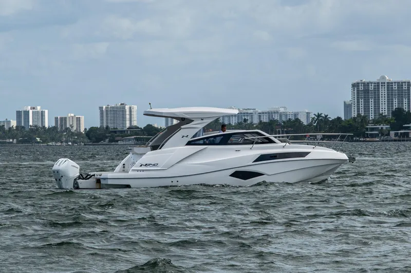 Xuru Yacht Photos Pics 2023 NX 340 boat cruising on water with city skyline in background.
