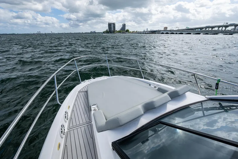 Xuru Yacht Photos Pics Luxury NX 340 yacht cruising on open water, 2023 model, with city skyline in background.