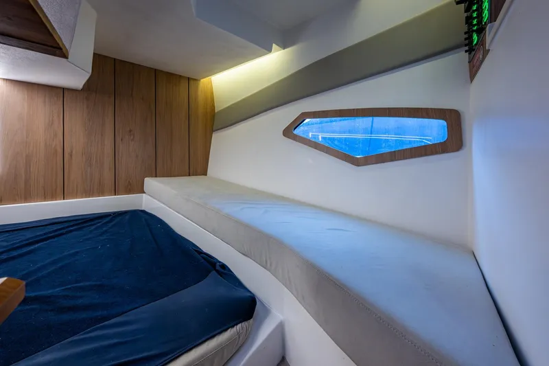 Xuru Yacht Photos Pics 2023 NX 340 interior cabin with wooden paneling and blue-lit window.