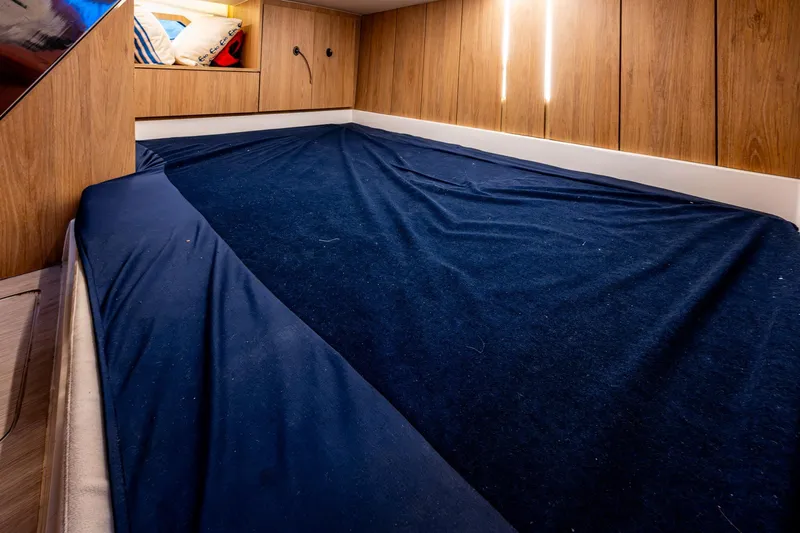 Xuru Yacht Photos Pics 2023 NX 340 interior cabin with blue bedding and wooden paneling.