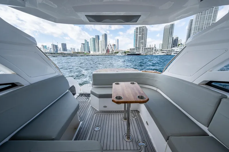 Xuru Yacht Photos Pics Luxurious 2023 NX 340 yacht interior with city skyline view, featuring sleek seating and table.